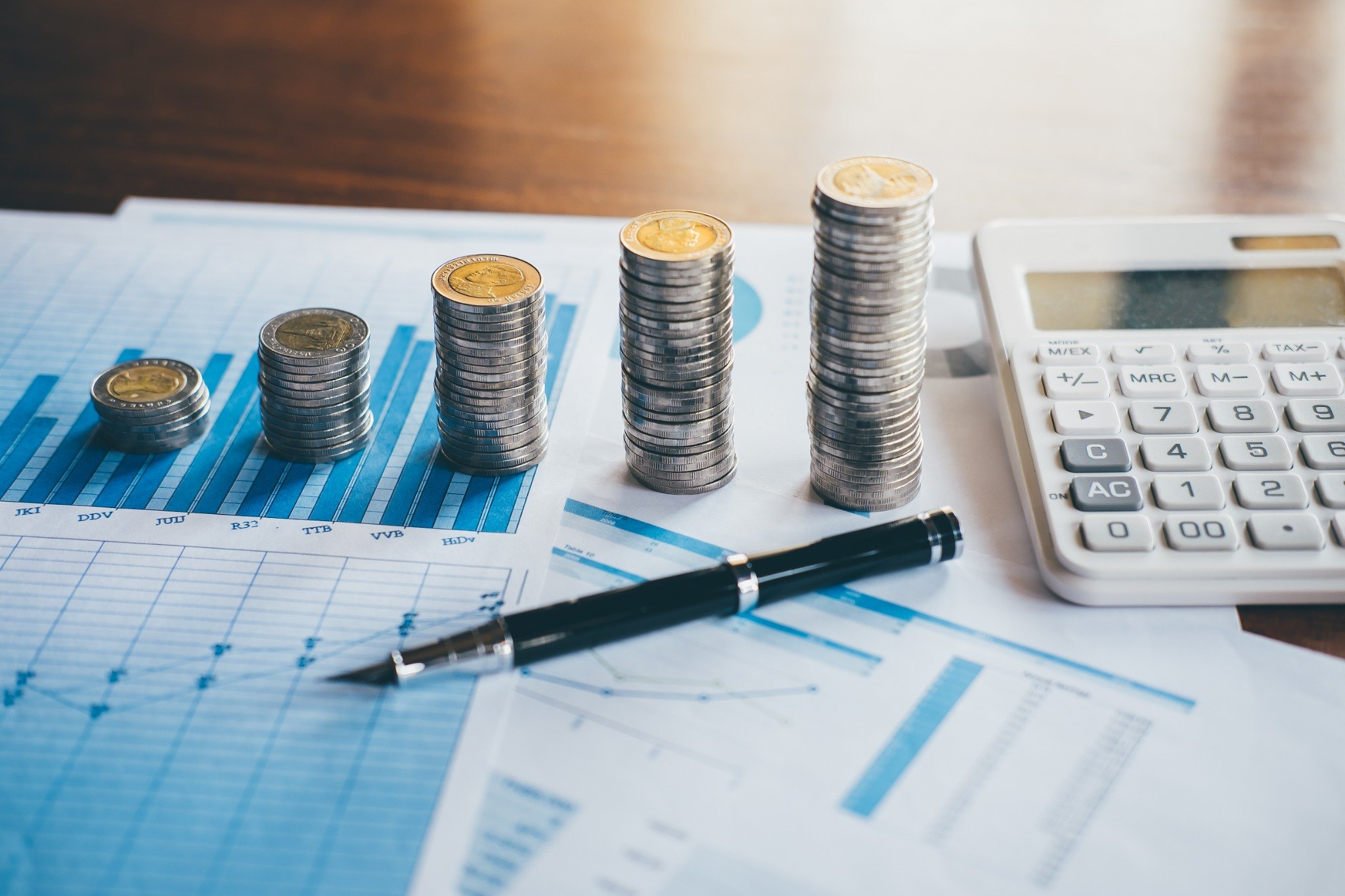 Financial charts, coins, pen and calculator